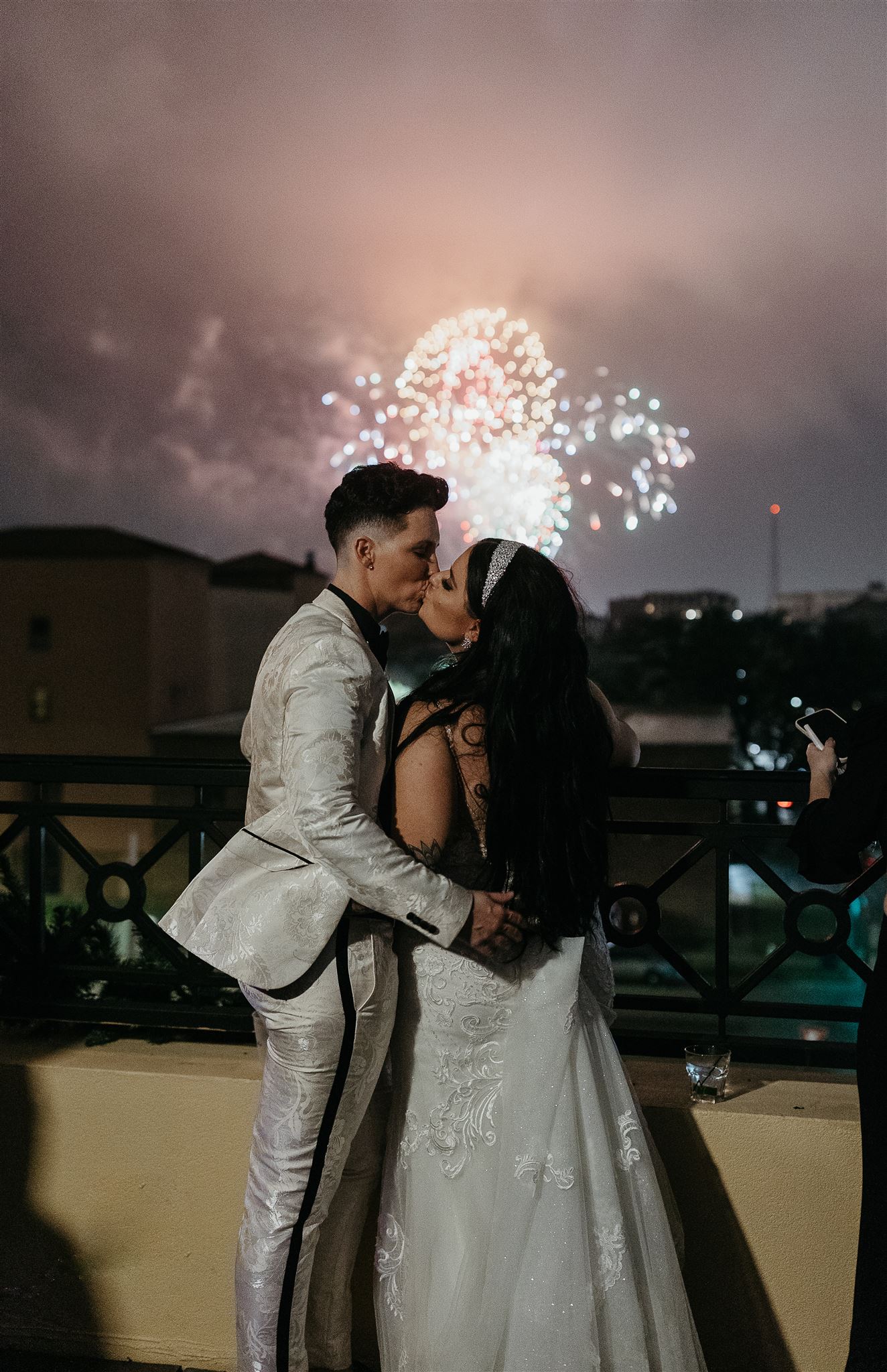 couple kisses in front of fireworks at a New Years Eve wedding