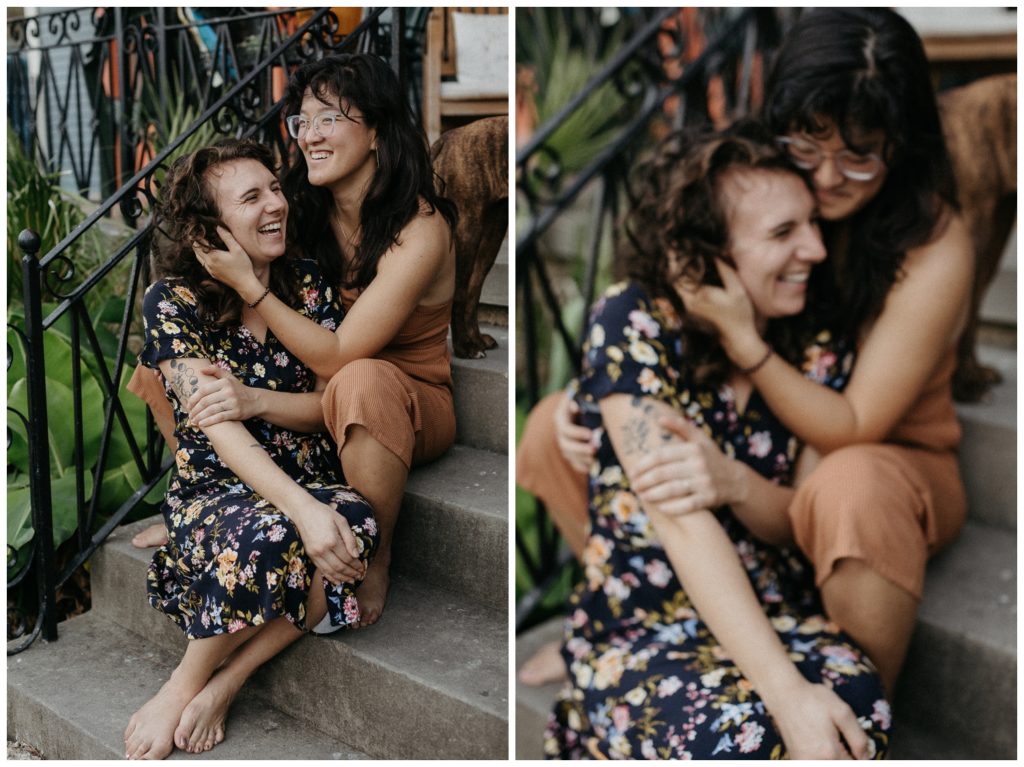 The couple laughs on the porch steps in their engagement photos at home