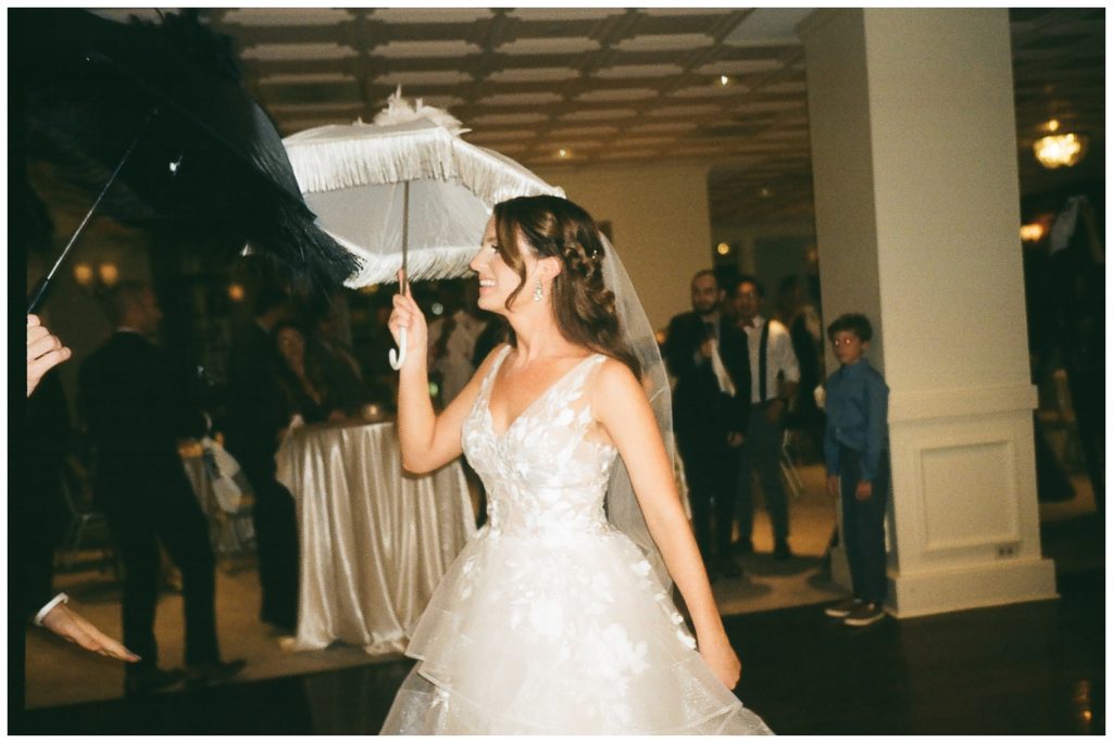 The bride holds a parasol