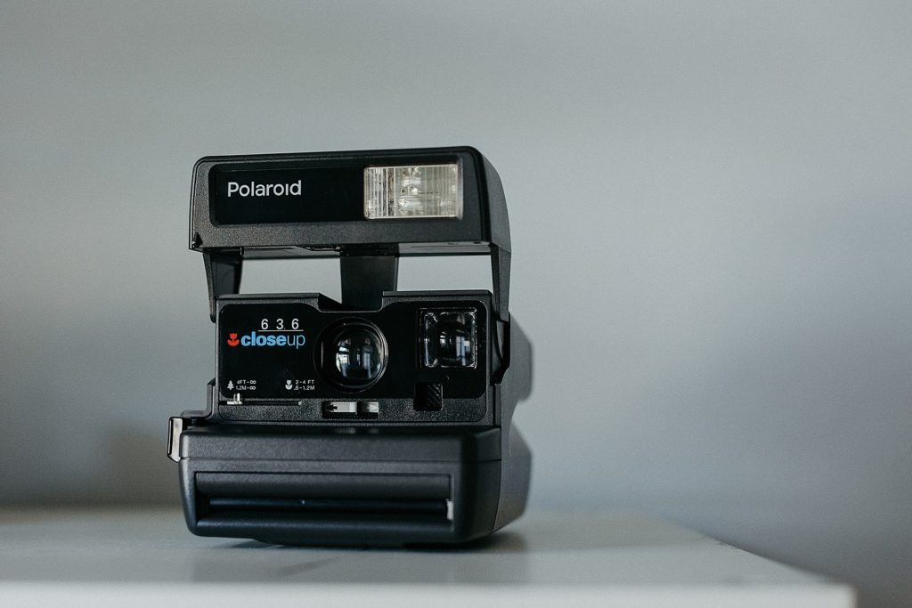 A Polaroid camera sits on a table
