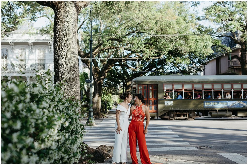 A New Orleans wedding couple stands on St. Charles as the streetcar passes by.