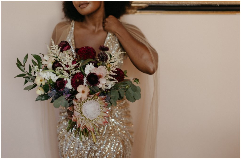 Isatu carries her wedding bouquet inside the Degas House.
