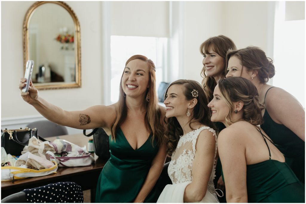 A bridesmaid takes a selfie with the bride and friends.