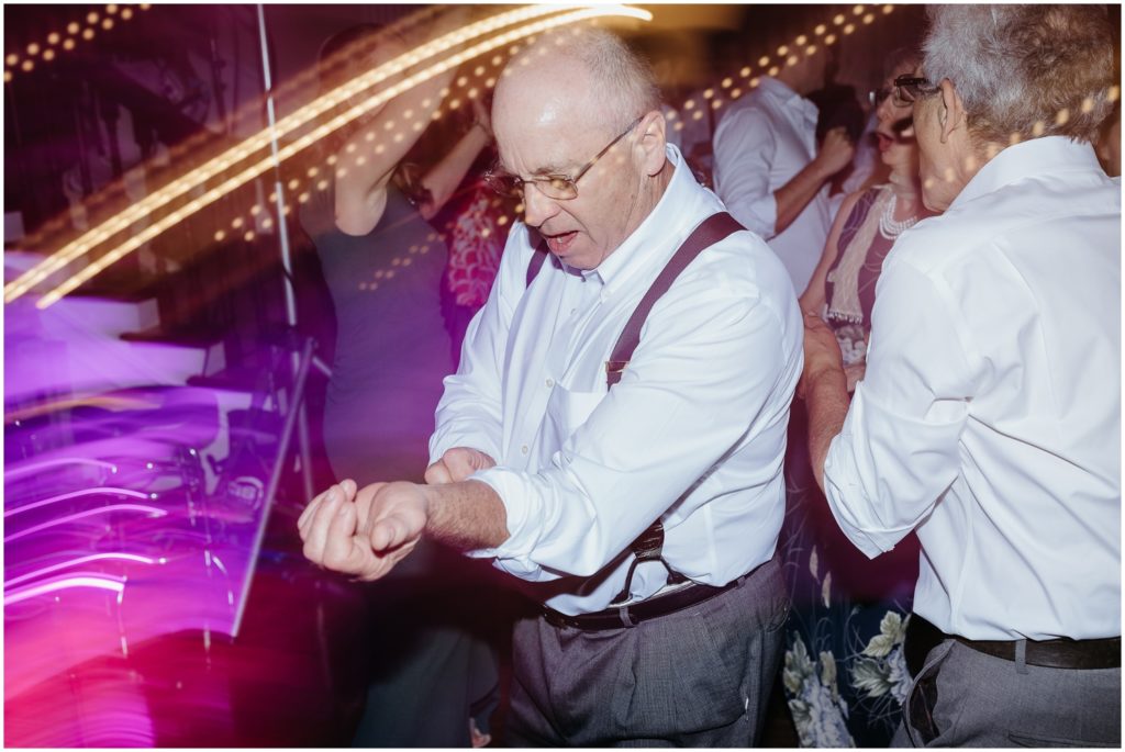 A wedding guest rolls up his sleeve during the dance party.