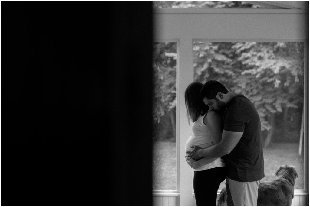 Through a doorway, Andrew kisses Stephanie's shoulder.