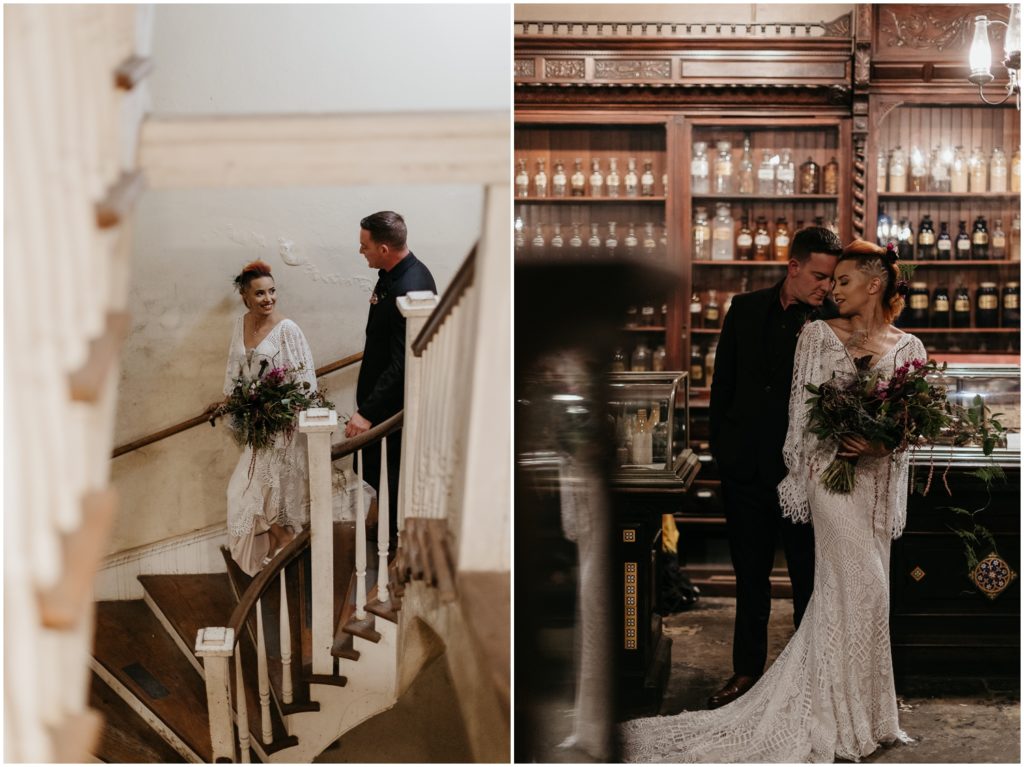 A bride and groom stand in front of shelves of antiques in the Pharmacy Museum.