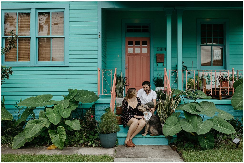 A man and woman celebrate their New Orleans proposal on their front porch.