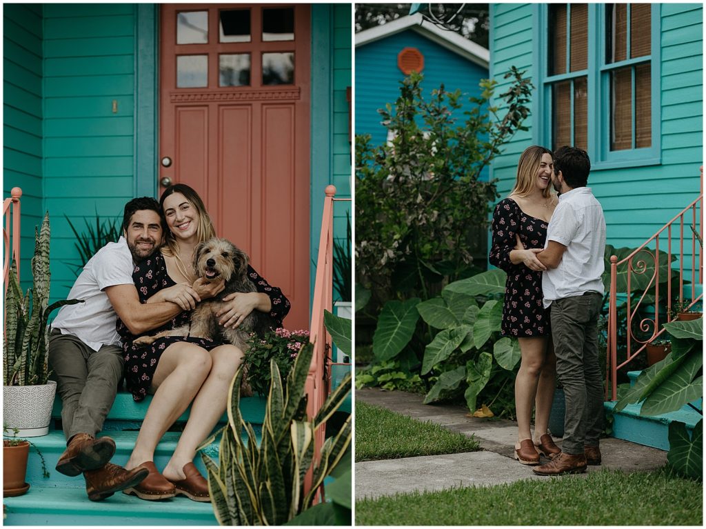 A couple embraces in front of their blue house.