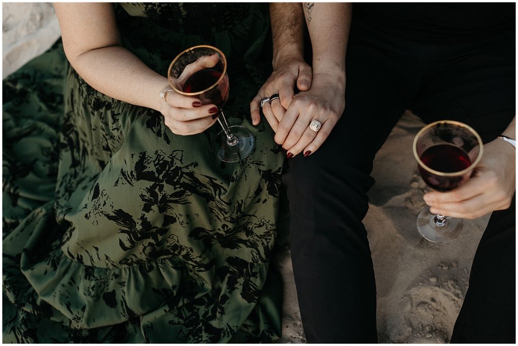 A woman wears an engagement ring after her New Orleans proposal as she drinks wine.