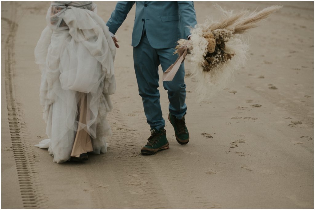 Holly lifts her wedding dress on the beach at her Oregon Coast elopement.