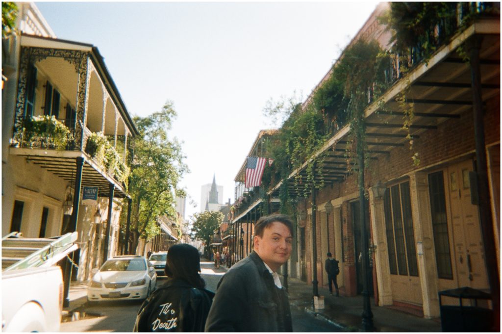 Nathaniel looks over his shoulder as Theresa leads him down a French Quarter street.