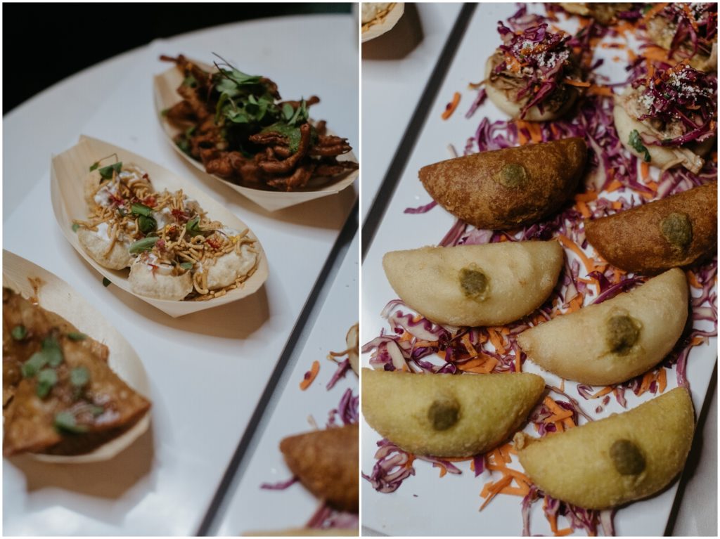 Empanadas and Indian appetizers sit on white plates.