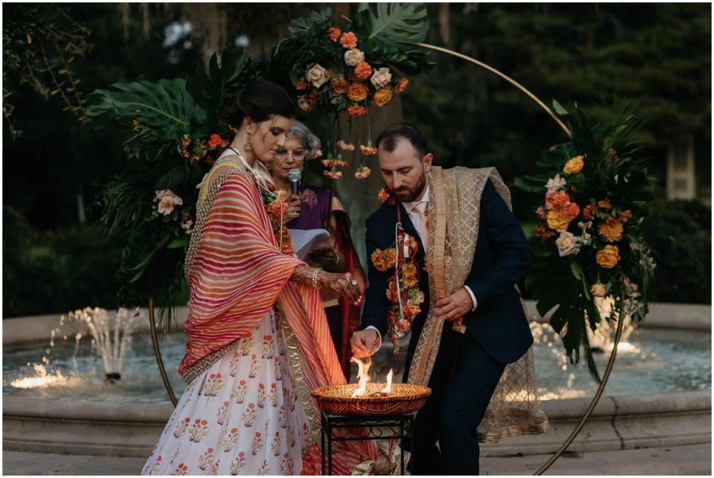 A bride and groom put incense on a fire at the wedding altar.
