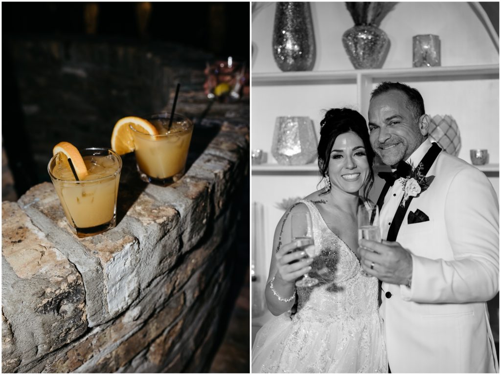 Orange cocktails sit in a line on a stone wall for the wedding cocktail hour.