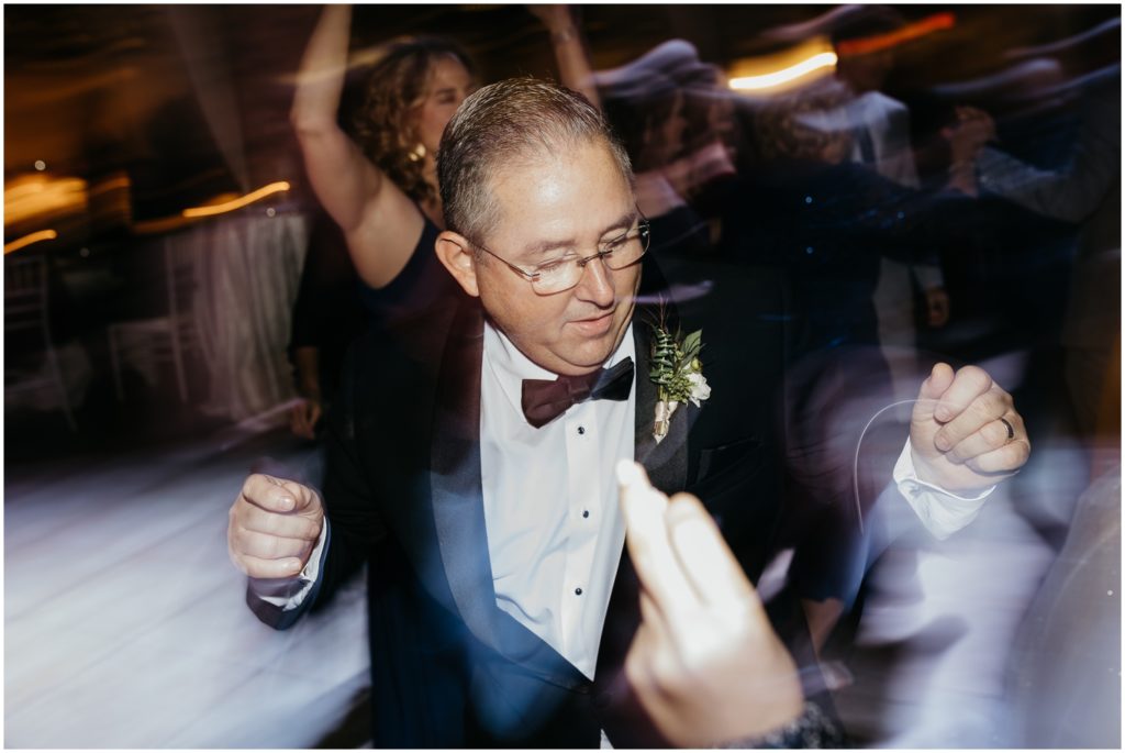 A wedding guest snaps his fingers on the dance floor.