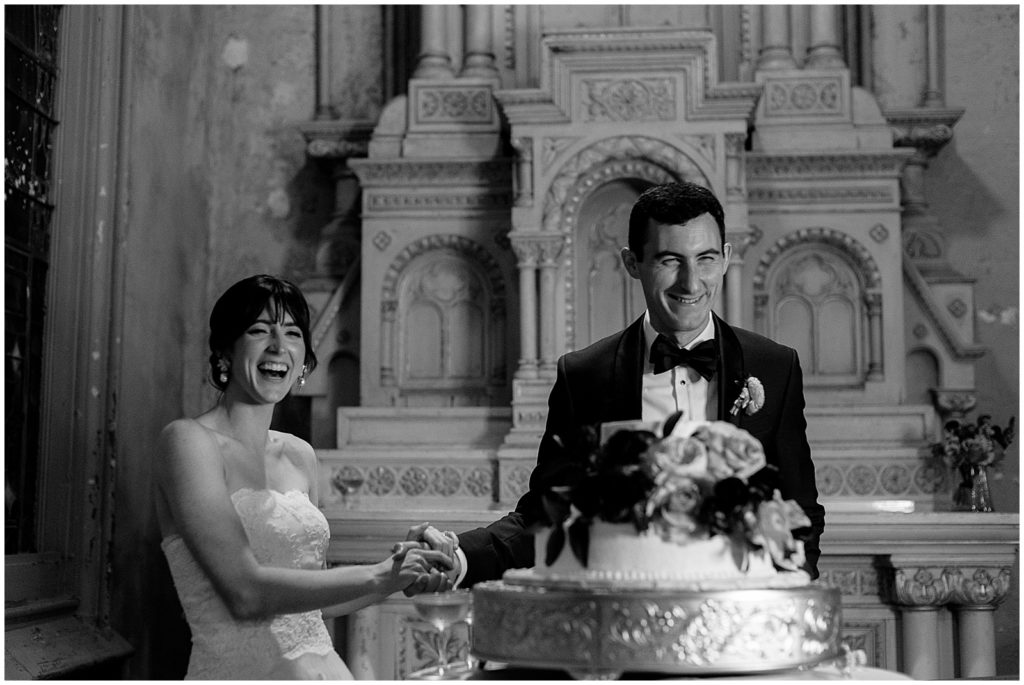 A bride and groom smile before they cut their wedding cake in Hotel Peter and Paul.