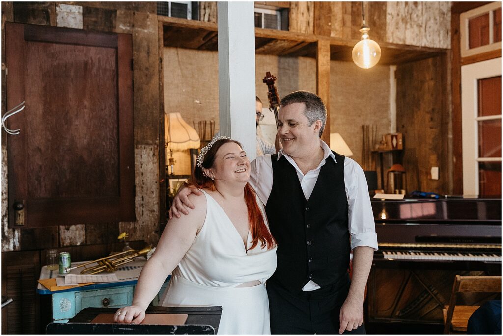 A bride and groom stand beside each other smiling at a morning wedding in a New Orleans wedding venue.