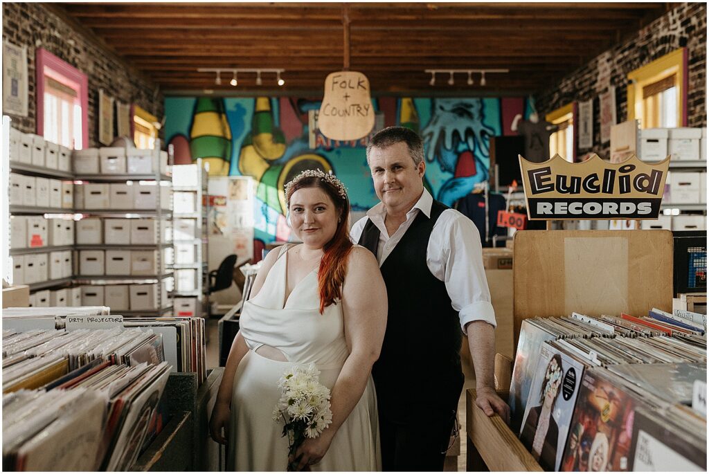 A bride and groom stand in the aisle of a new Orleans record shop.